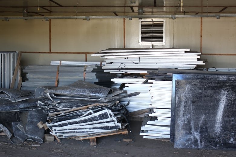 A stack of damaged solar panels is pictured at the Sunset Renewables site in Brooks.