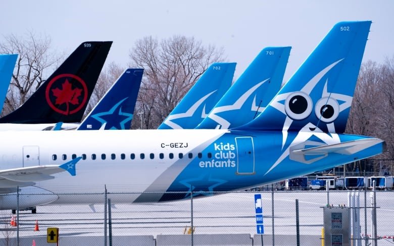 The tails of five airliners are seen on an airport's tarmac.