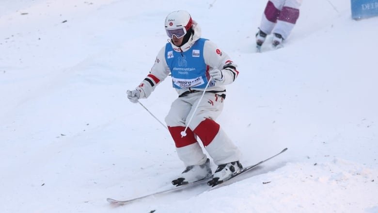 A male skier speeds down a dual moguls course during a race.