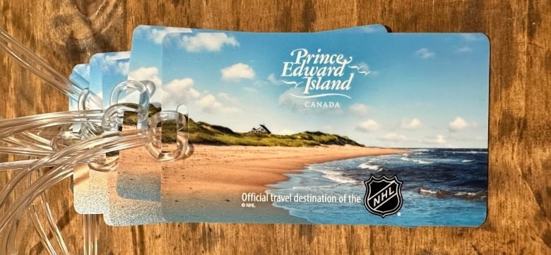 A tag depicting P.E.I. scenery with the NHL logo and Tourism P.E.I. logo with the words official travel destination.