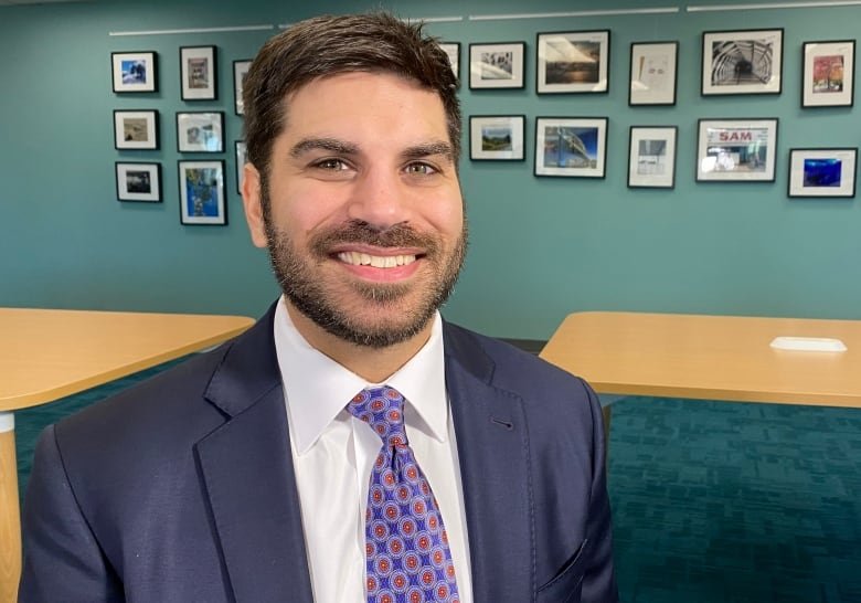 Man in a suit standing in a room.