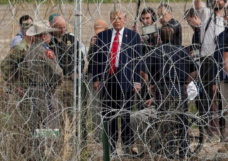 Trump seen through wire fence