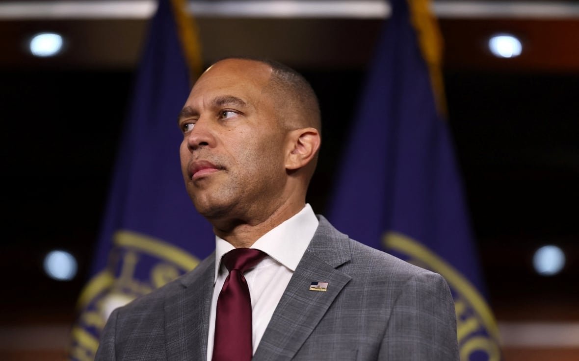 U.S. House Minority Leader Hakeem Jeffries is seen listening to colleagues speaking to members of the media.