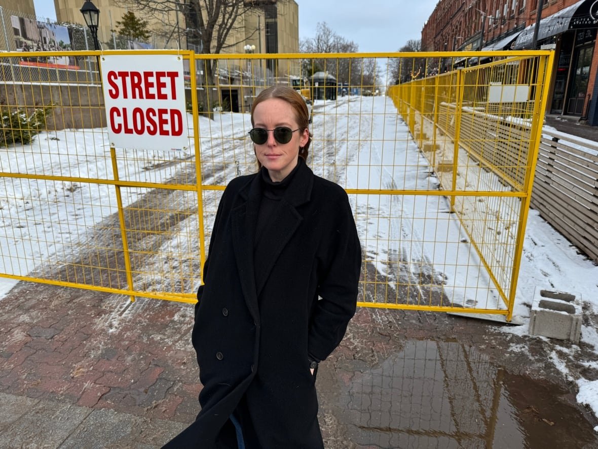 Woman standing in front of sign that says Street Closed.