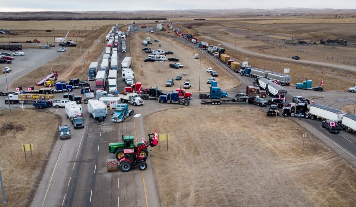 An aerial view of trucks blocking both sides of the highway.