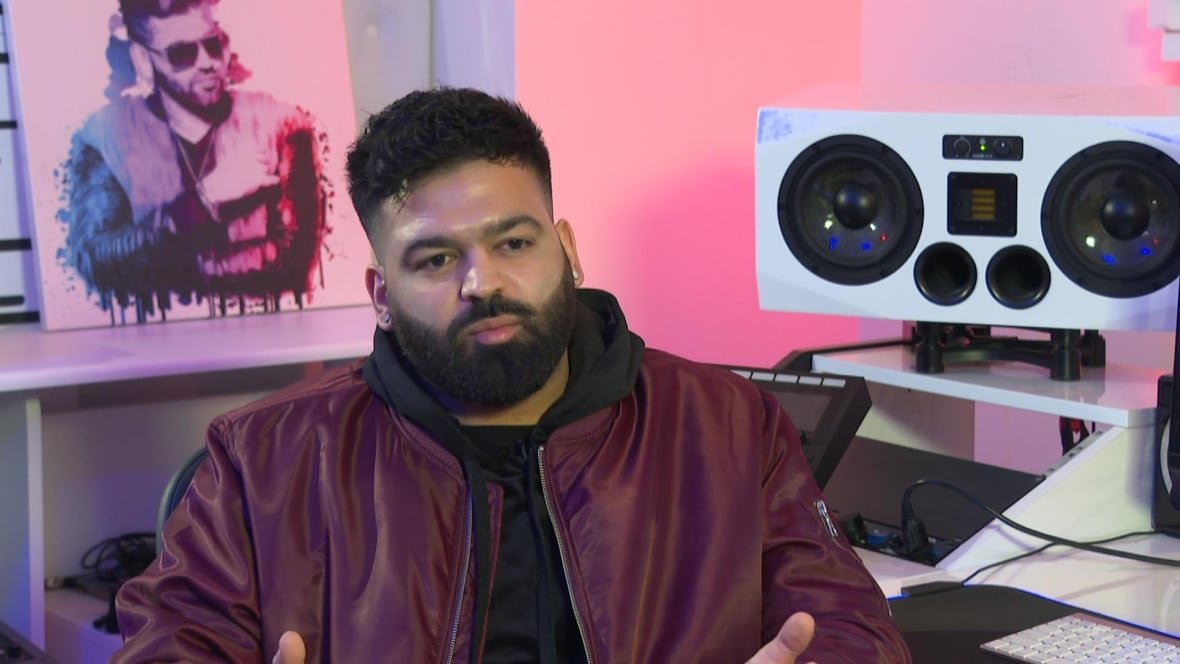 harj-nagra A man wearing a burgundy jacket sits in a recording studio.