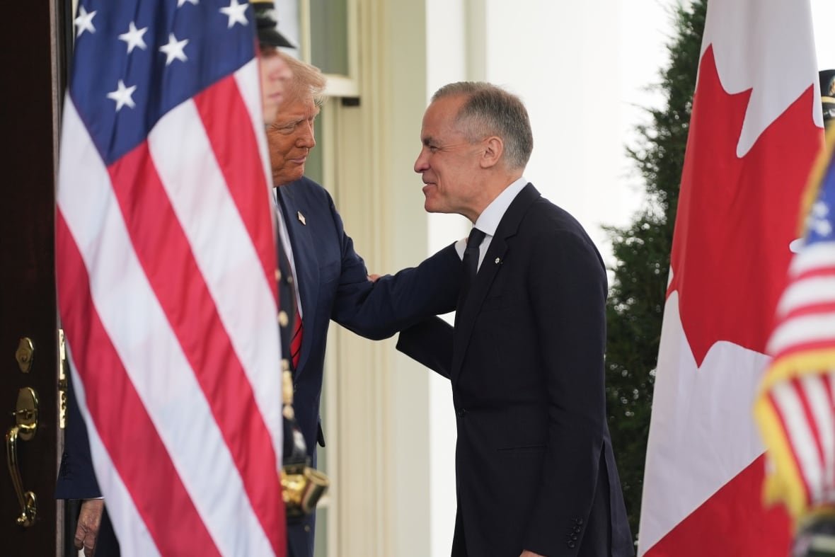 trump Two men greet each other by an American flag.