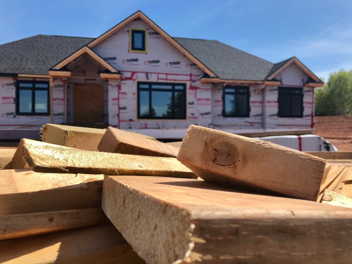 67176 A photo of stacked wood in front of a nearly finished single fmaily home in Charlottetown.