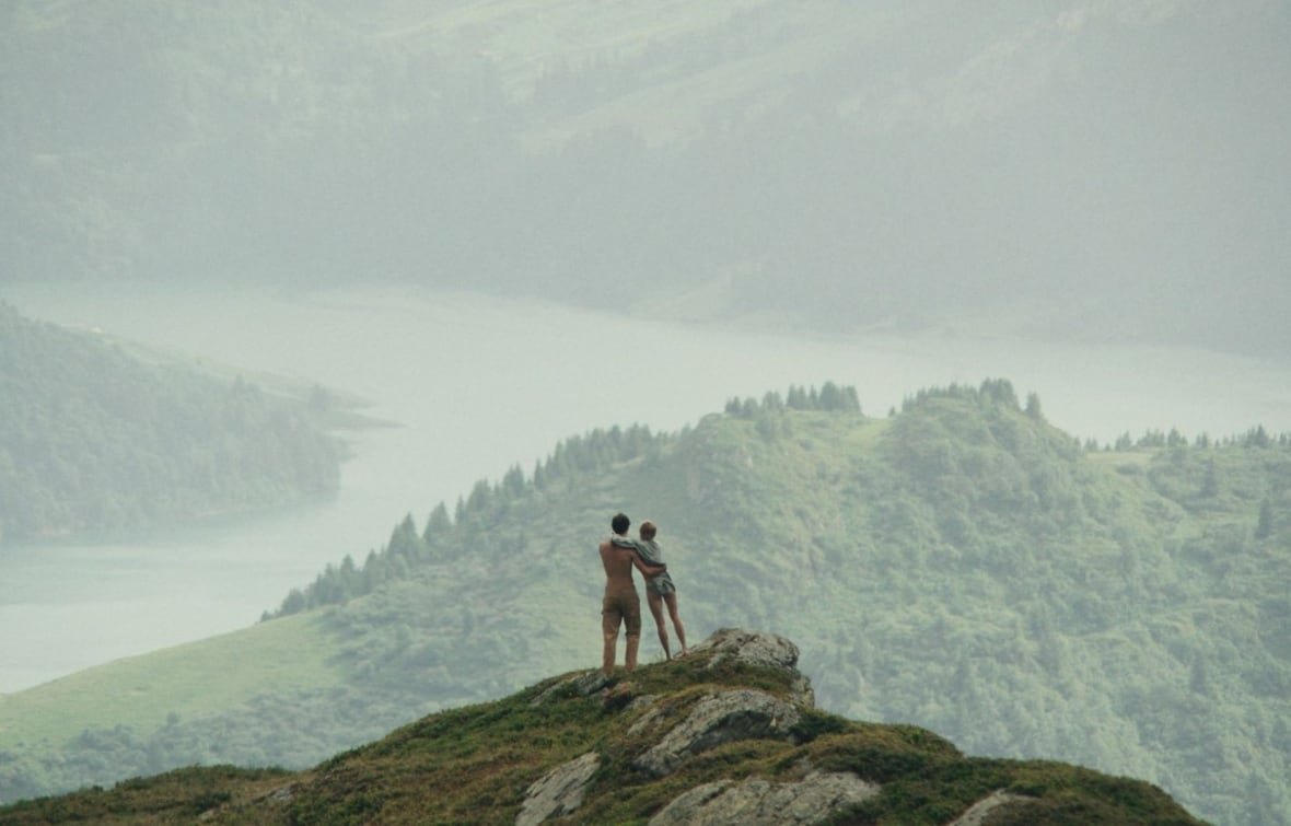bergers Two people overlook a scenic hillside.