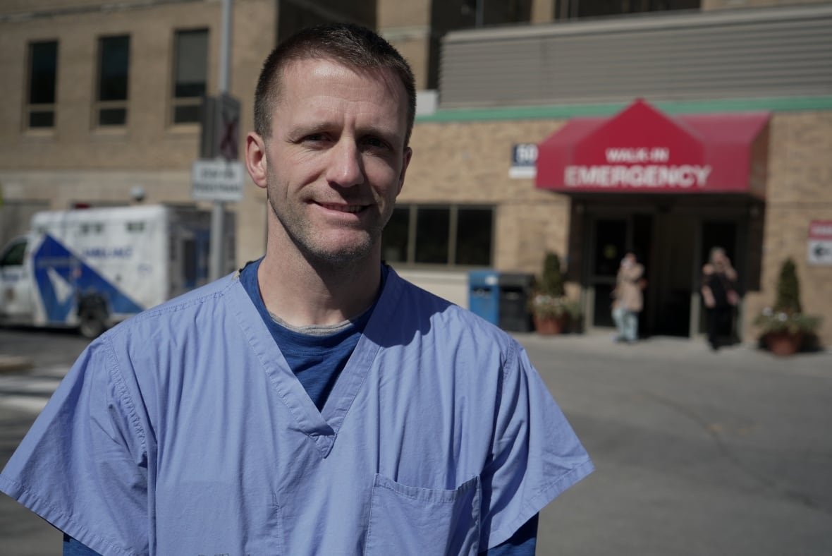 dr-justin-hall Dr. Hall is pictured outside the hospital Emergency Department entrance, wearing blue scrubs