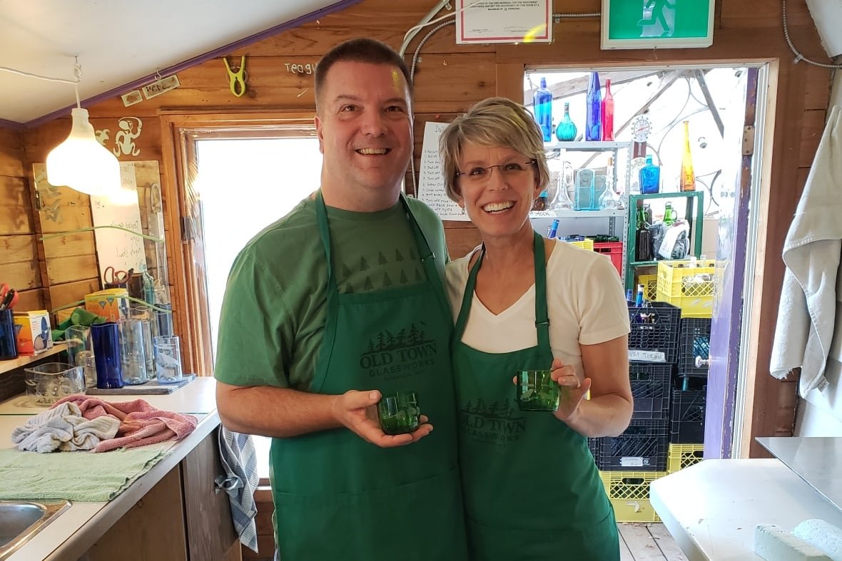 glenn-and-sandi-edgemon A couple in green aprons pose for a photo.