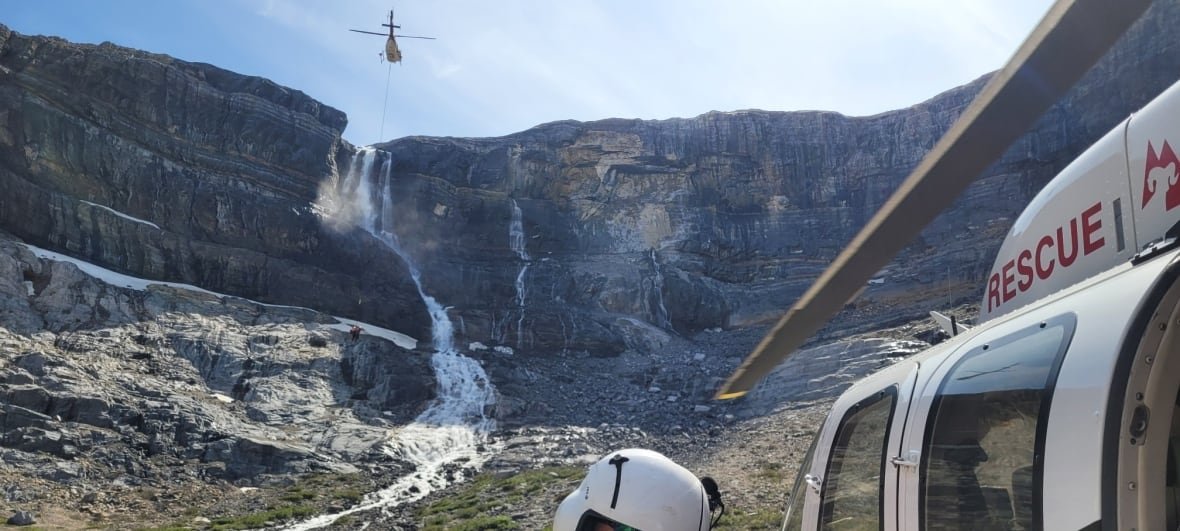 helicopter-rescue-banff-bow-glacier-falls A helicopter nears a crack in a mountain.