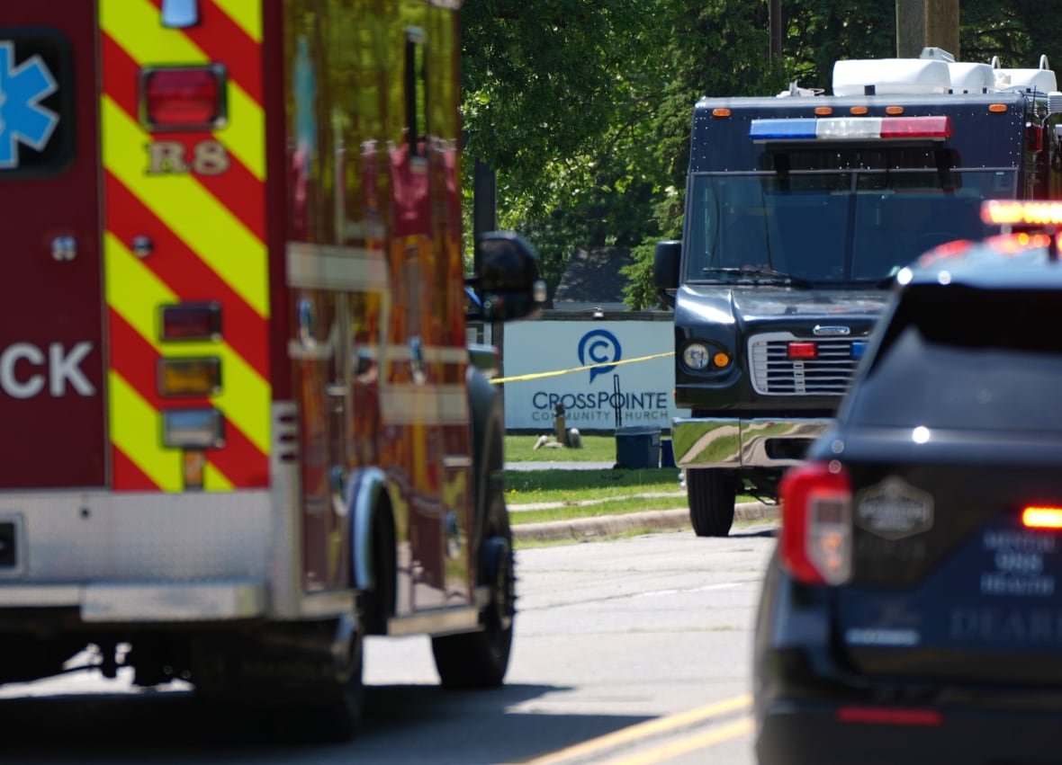 michigan-church-shooting-2 Emergency vehicles shown on a street with a sign for a church in the background.