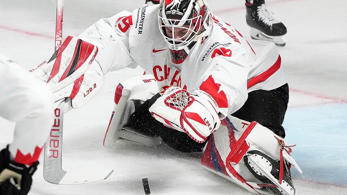 montembeault-sam-230515-1180 Canadian men's goalie tries to corral rolling puck in game at the world hockey championship.