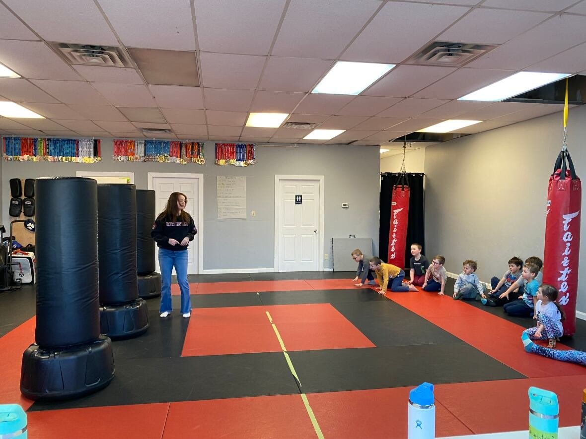 northstar-martial-arts A group of children sit on gym mats during a martial arts class.
