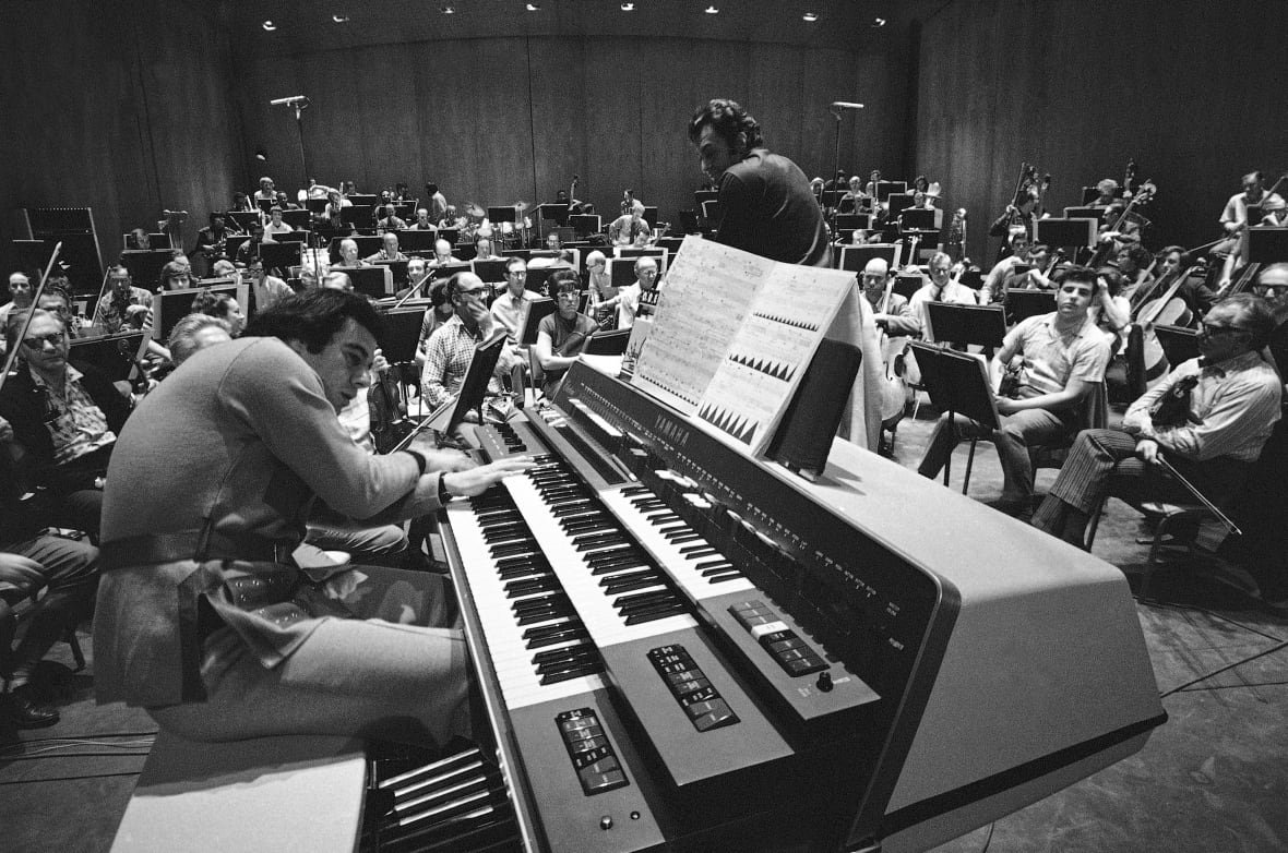 obit-lalo-schifrin-1 A man plays piano on stage.