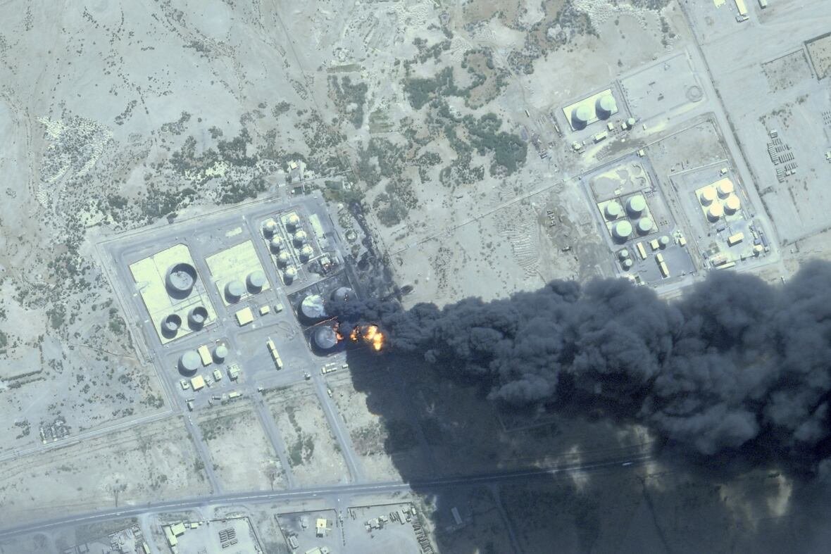 sudan-1 A large cloud of black smoke is shown in a satellite photo with an aerial view.