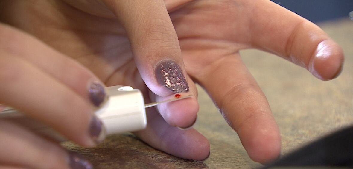 type-one-diabetes Person uses a traditional strip test to calibrate her continuous glucose monitoring device.