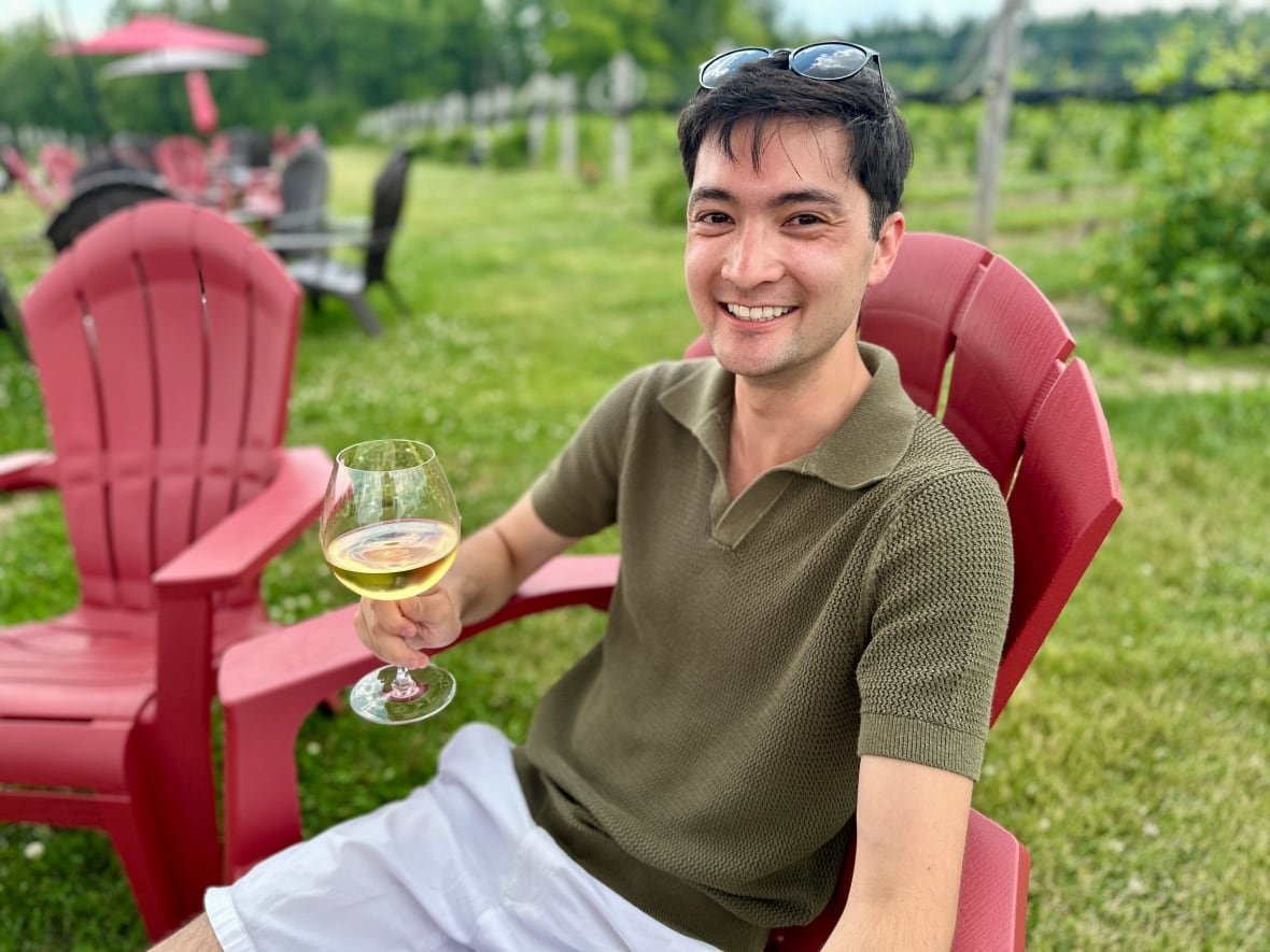 william-hordyk man in green shirt in red chair with wine glass