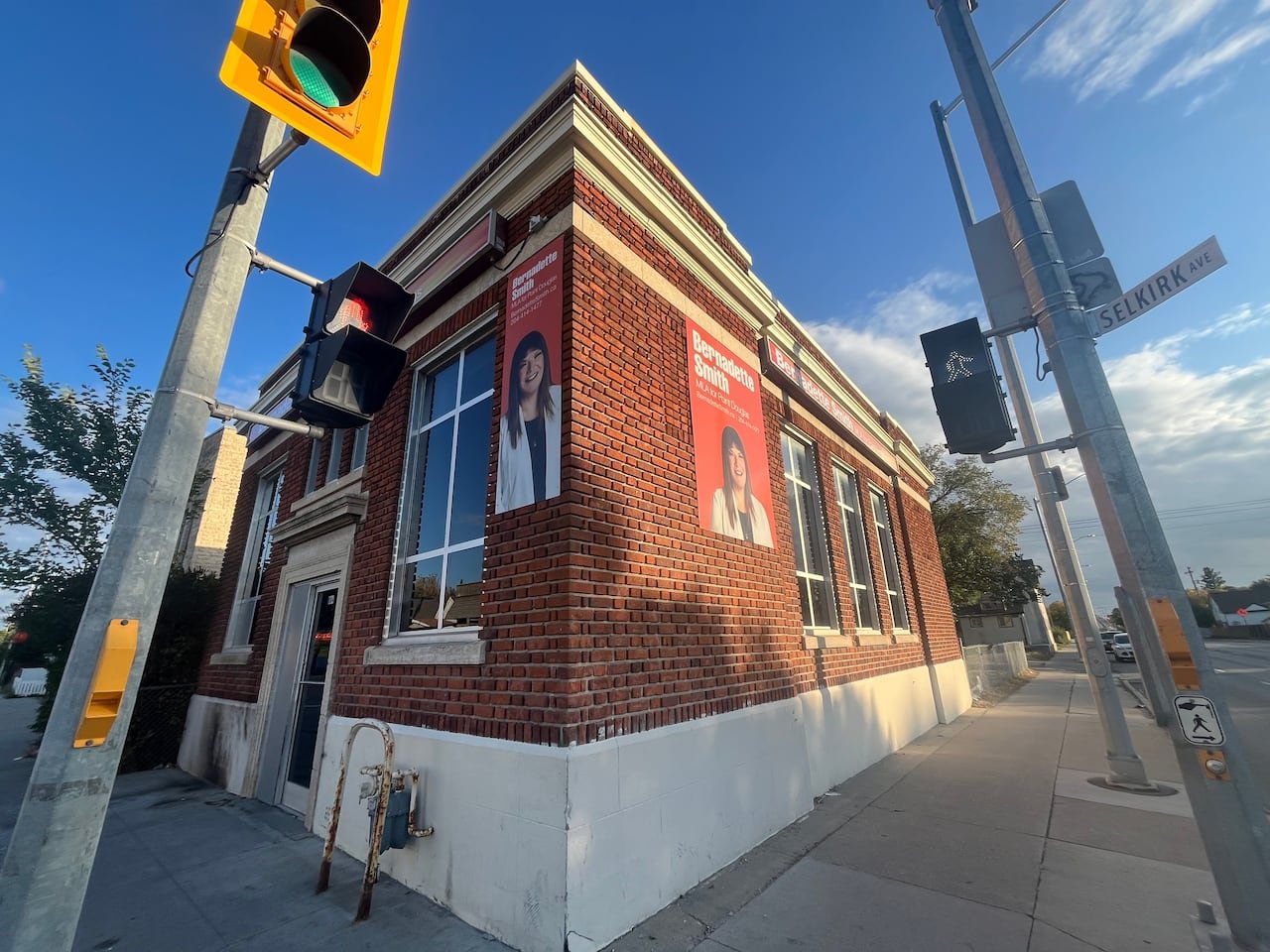 A brick building adorned with posters featuring Point Douglas MLA Bernadette Smith.