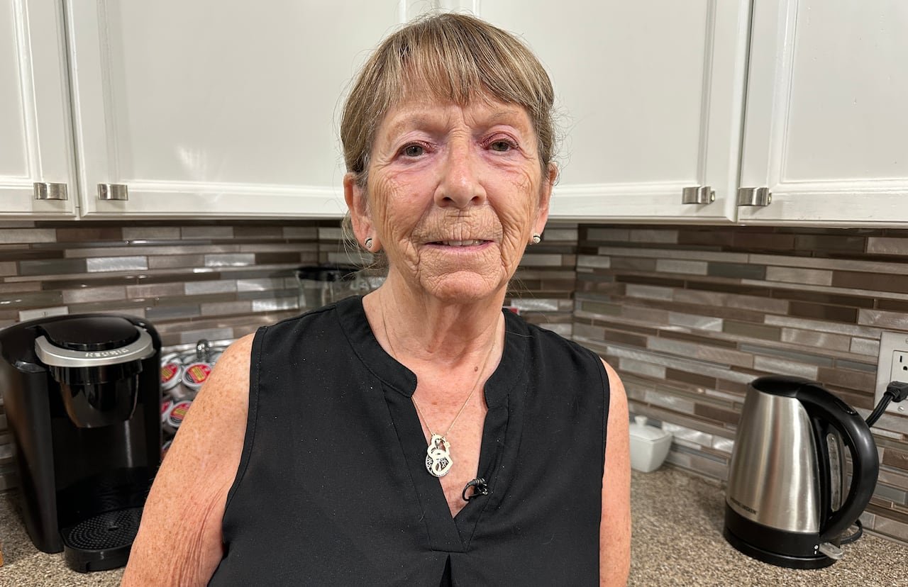 Woman standing in her kitchen.