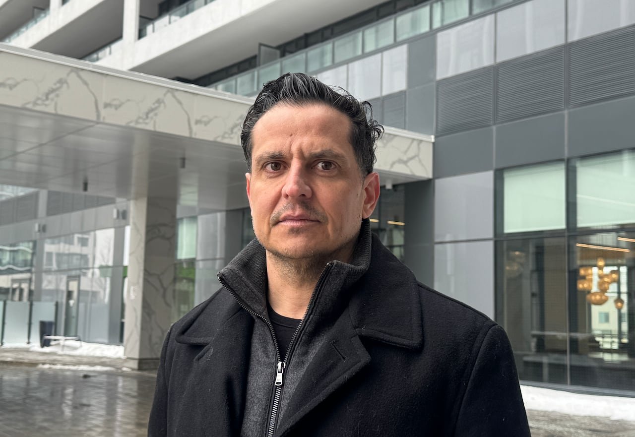 default-851 A man stands in front of a condo building