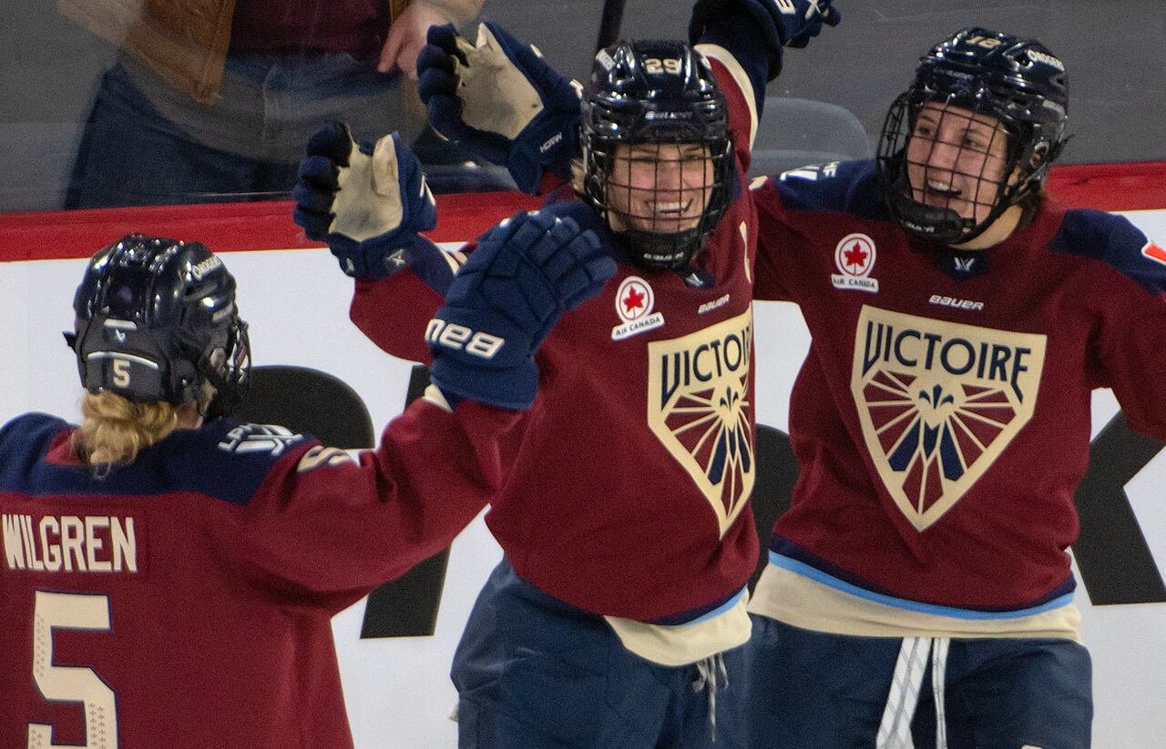 Three hockey players celebrate