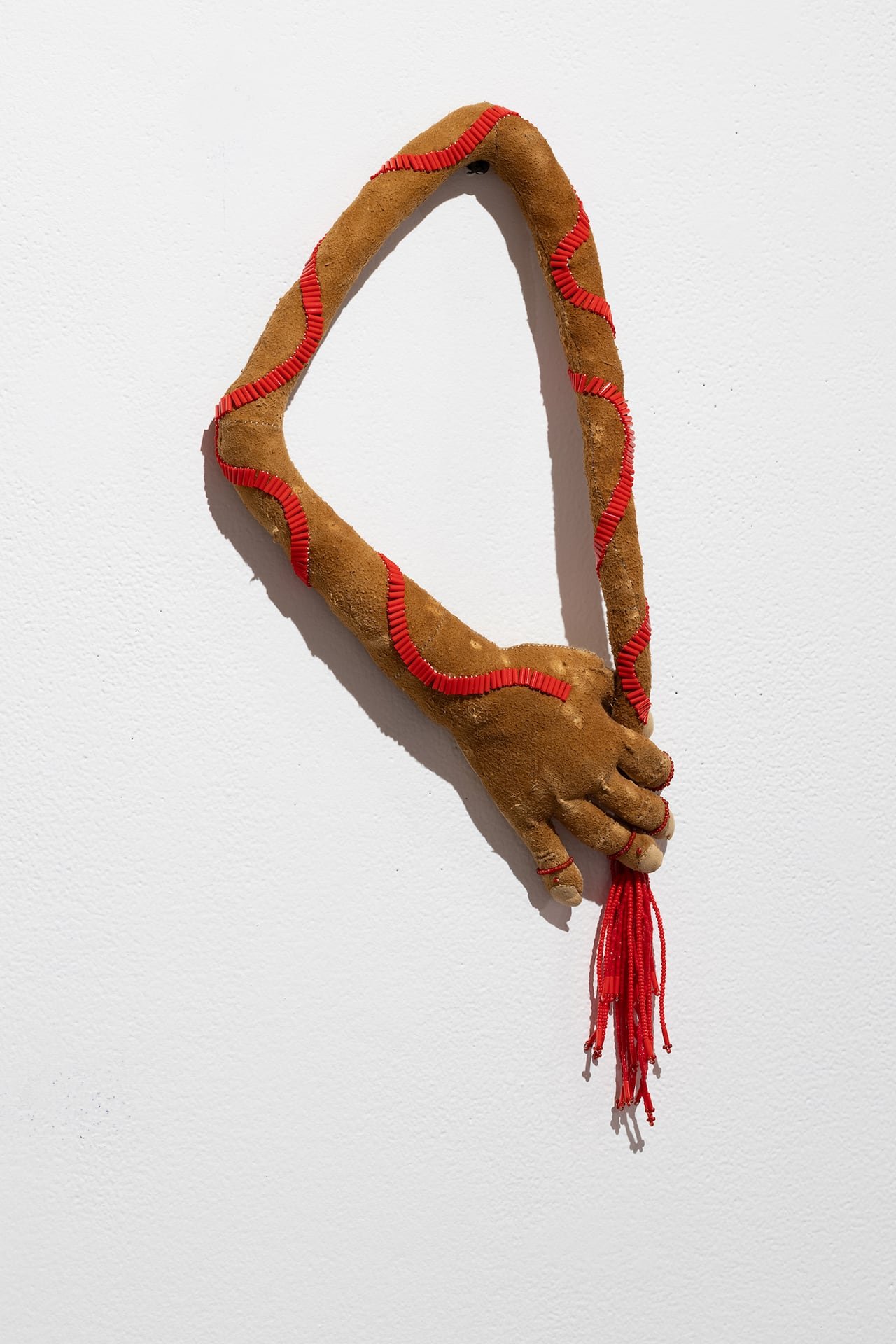 default-553 Artwork of a hand and arm bending around to itself. Made of caribou hide, beaver fur and beads.