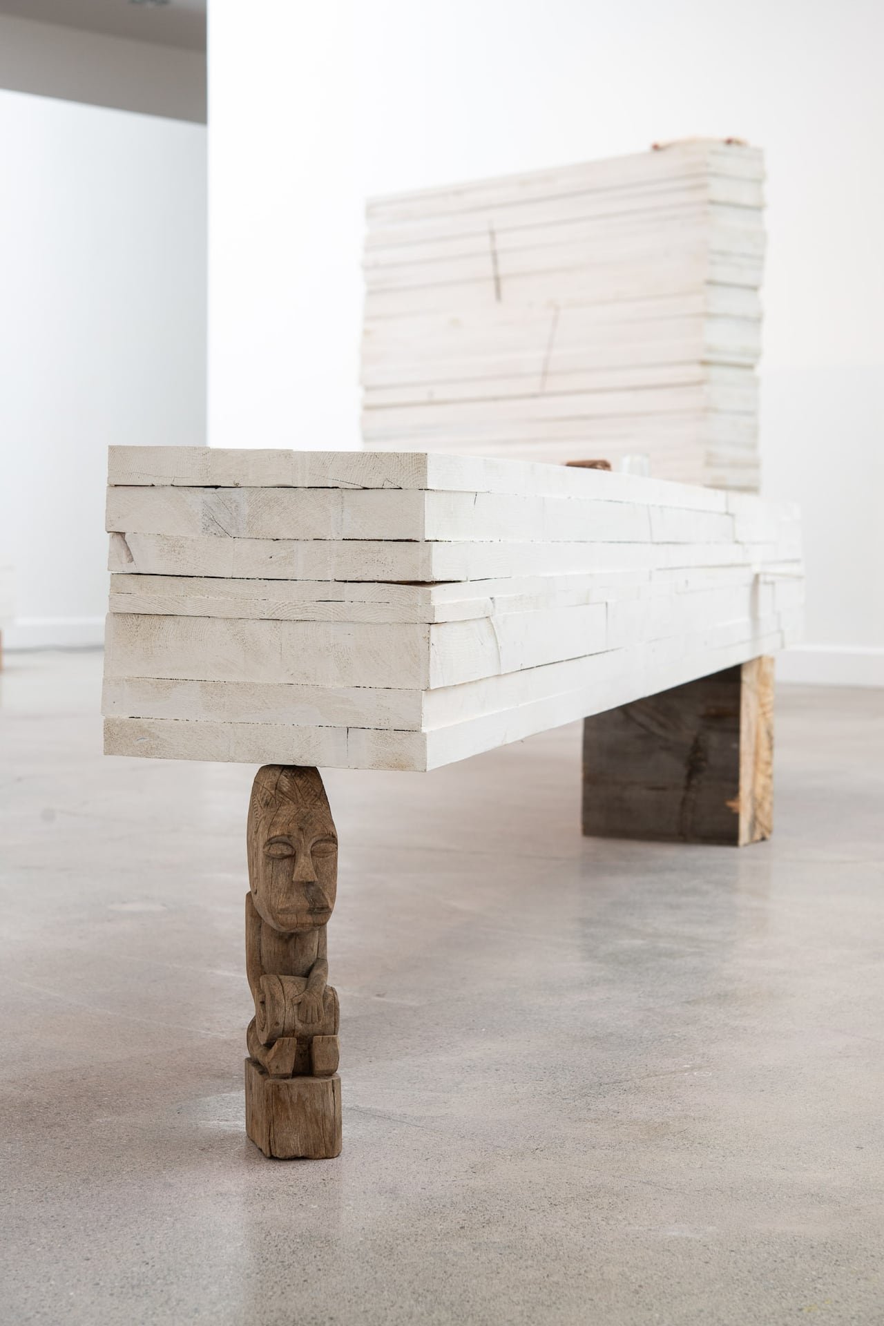 default-554 Artwork. Grey flat material balanced on a small carved sculpture.