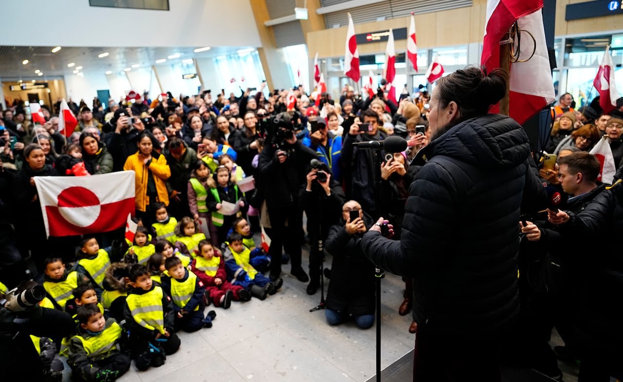 Greenland's Minister for Foreign Affairs, Vivian Motzfeldt, speaks to a crowd in an airport