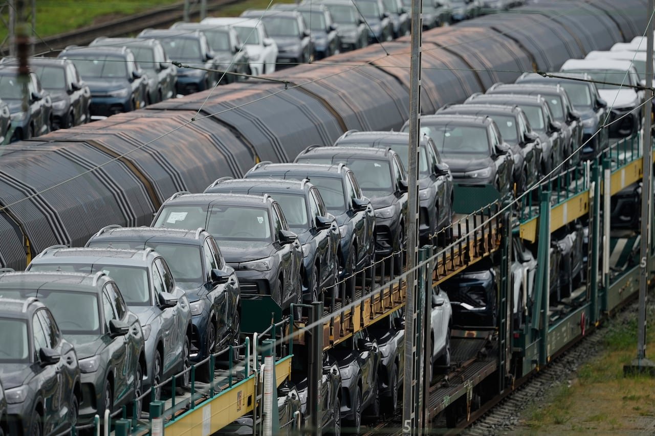 Many cars are seen being shipped via train.