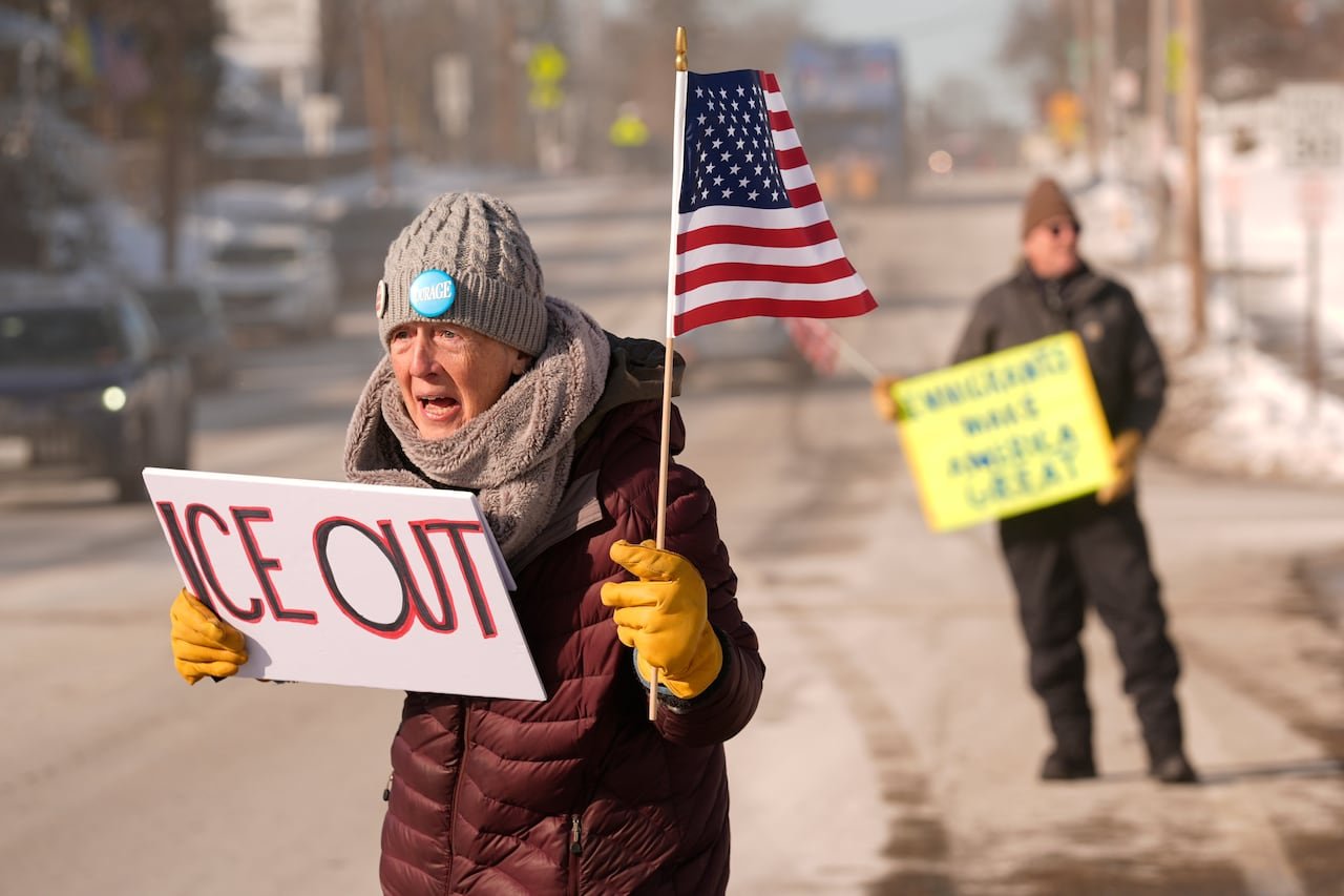 default-731 A protestor wearing winter clothing holds a sign that says "ICE out."