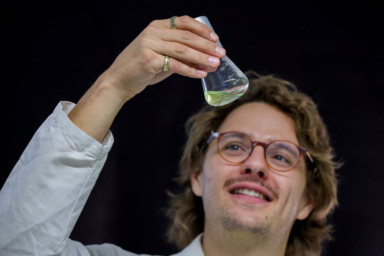 default-205 A scientist in a lab coat holding a flask with a substance.