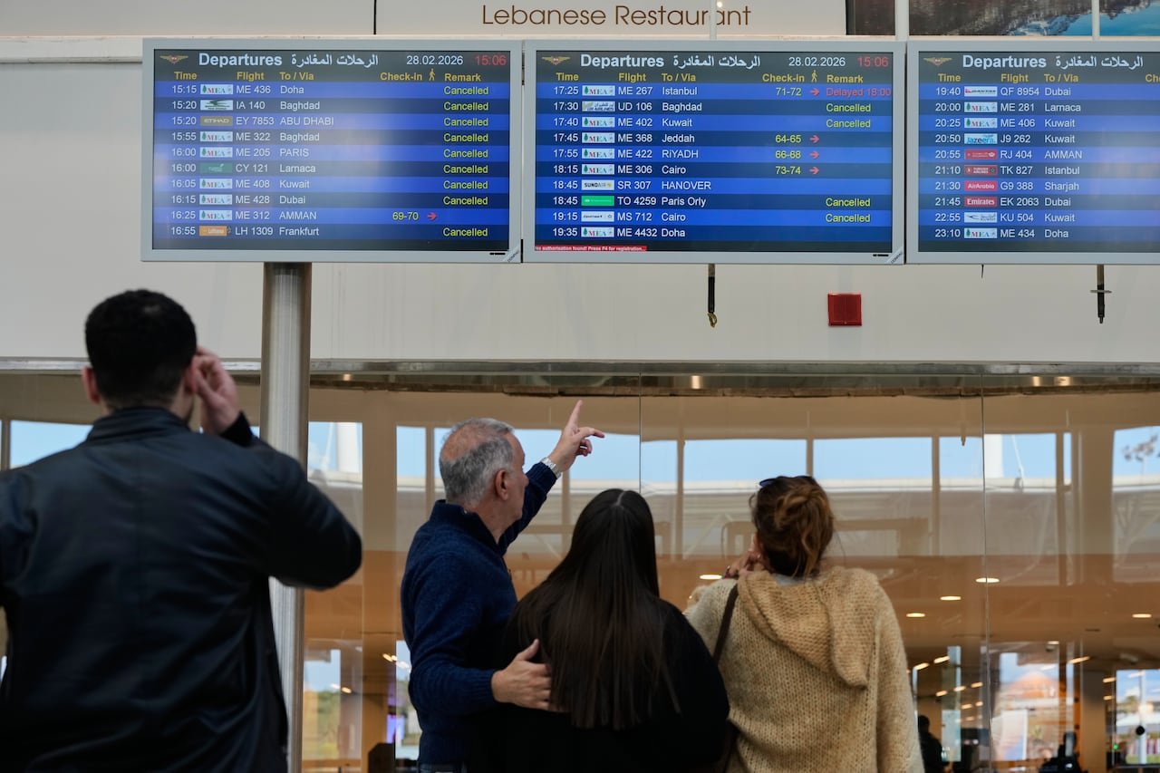 default-329 People check departure times on a screen at an airport.