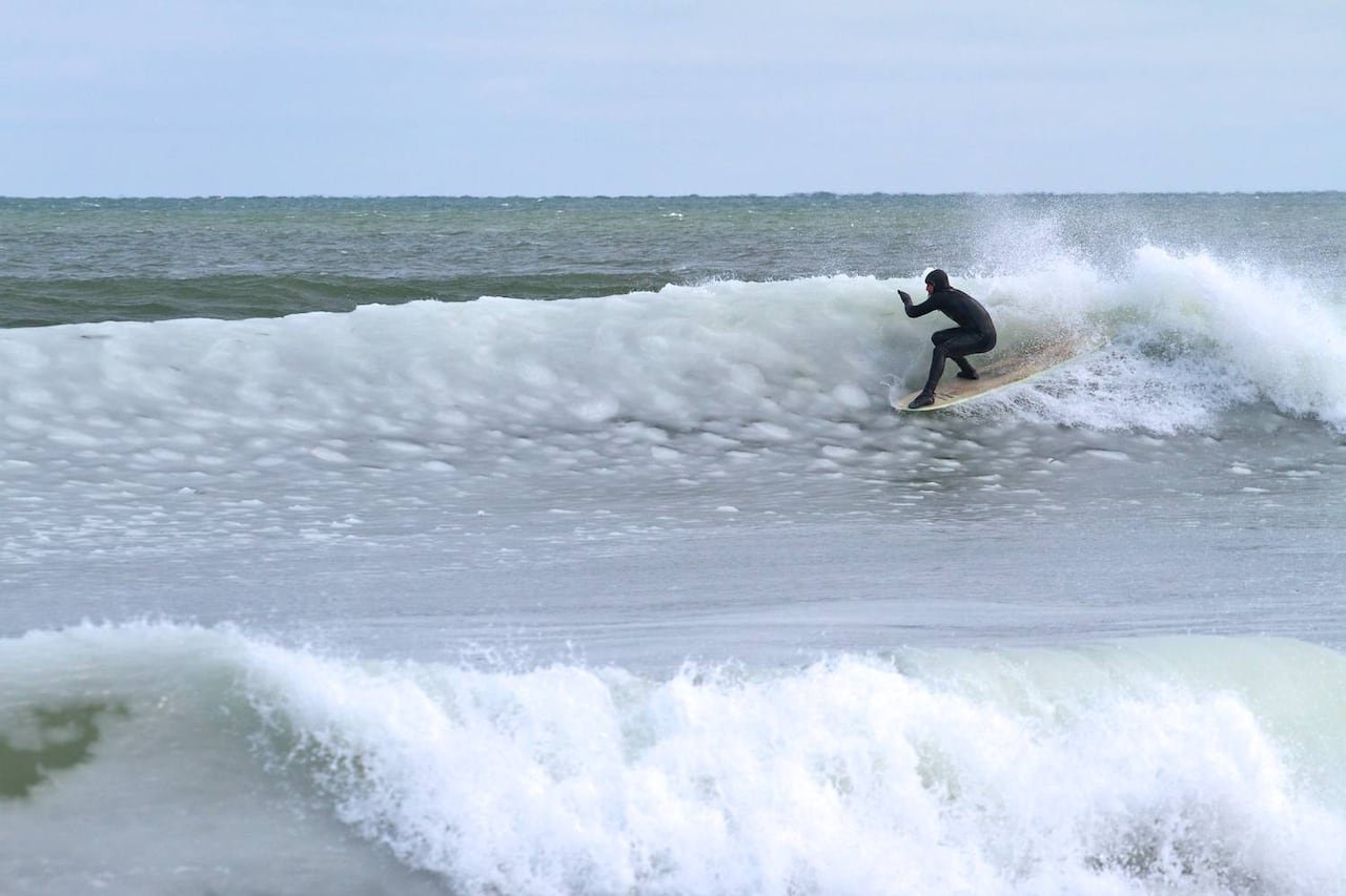 default-519 A man in a wetsuit surfs a wave in the winter.